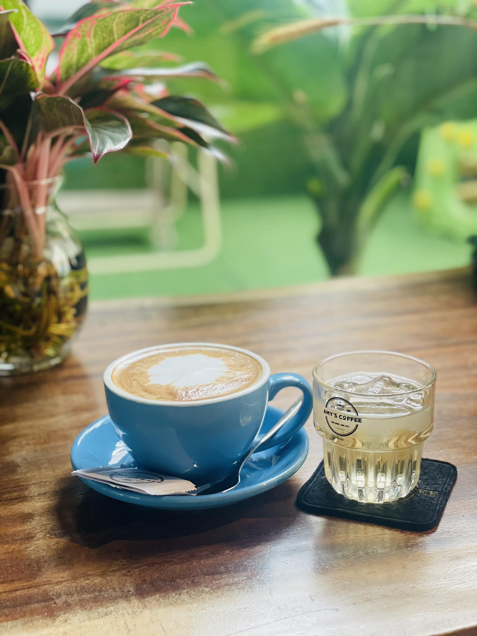 Bàn ghế gỗ và lọ hoa tại Amy's Coffee